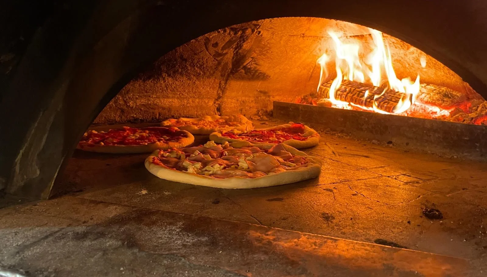 Pizza pečená v peci na bukovom dreve s otvoreným ohňom